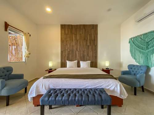 King bedroom with abundant natural light and a seating bench