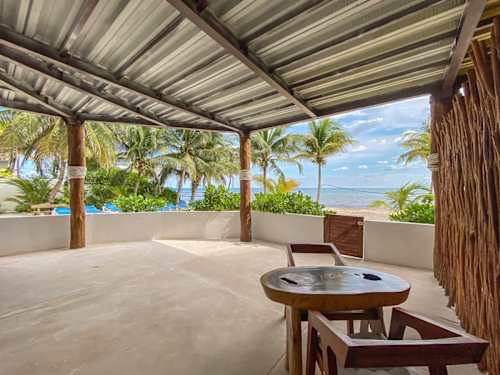 Shared beachfront palapa lounge steps from the sand