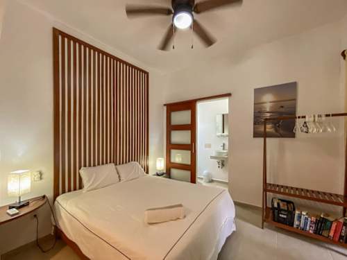 NIKTE studio - King bed, ceiling fan and wood accent wall