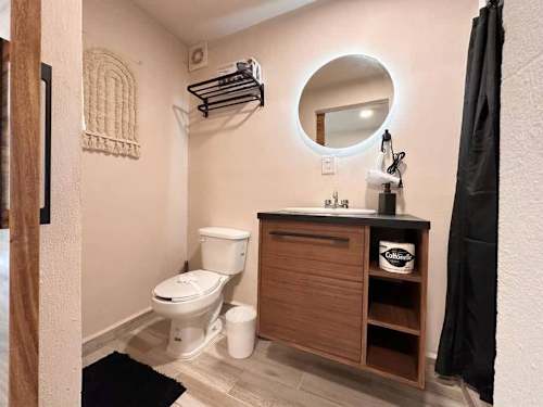 Private bathroom with stylish round mirror