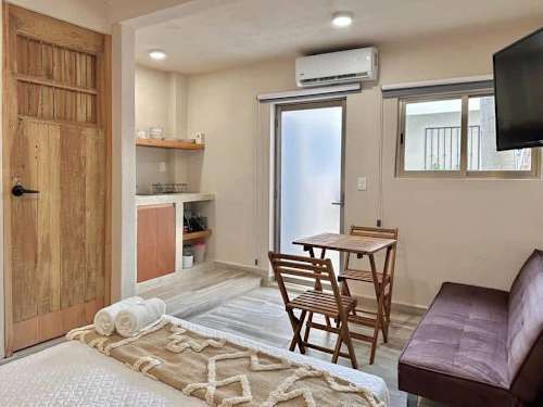 Studio living area with sofa bed, dining table and Smart TV.
