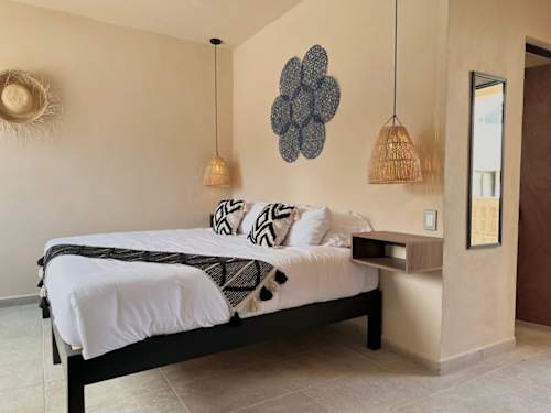 King bed with stylish decor and pendant lighting