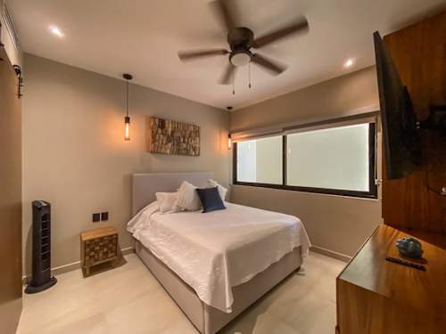 Serene bedroom bathed in natural light, a peaceful escape just steps from the Caribbean