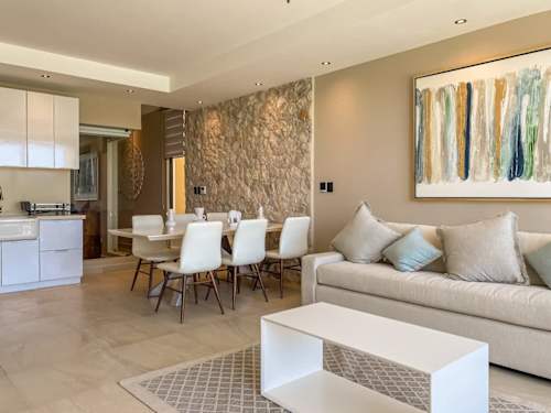 Open concept dining framed by a natural stone wall, bright and airy for easy island living
