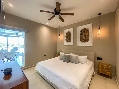 Restful bedroom with a plush bed and soft ceiling fan breeze, made for deep sleep after a day by the sea