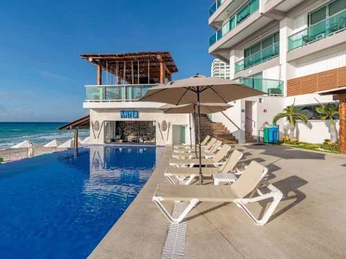 Beachfront condominium with communal pool deck and palms (shared)