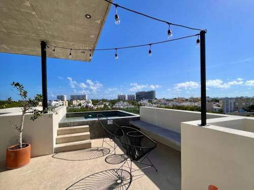 Shared rooftop pool and lounge with string lights (common area)