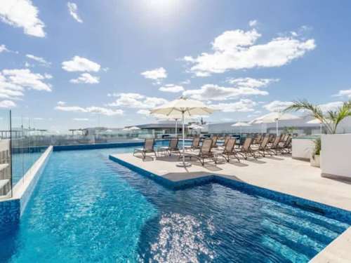 Shared rooftop pool deck with lounge seating