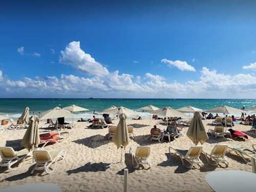 Sun-soaked Caribbean beach with loungers and umbrellas, a short walk away