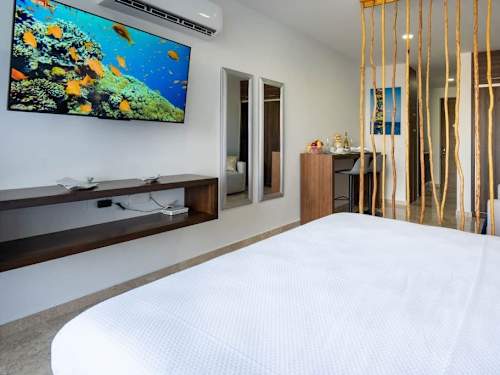 Comfortable king bed with a smart TV and stylish decor for an easy Riviera Maya stay