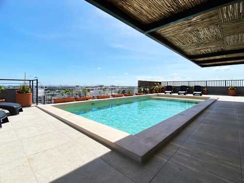 Shared rooftop pool with loungers