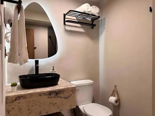 Full bathroom with vanity and round mirror