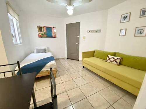 Flexible living area pairing a sofa with an extra single bed, smart space for a group