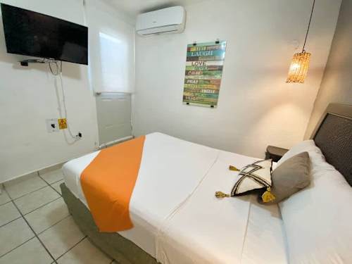 Comfortable bedroom with a fresh double bed, wall-mounted TV and AC for cool, restful nights
