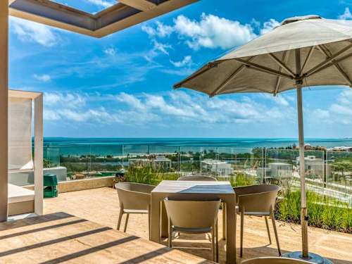 Shared rooftop terrace with dining tables and ocean views