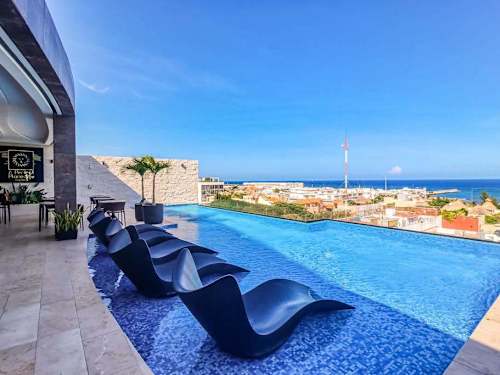 Shared rooftop infinity pool with ocean and town views