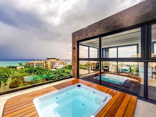Shared rooftop pool with seating and ocean views