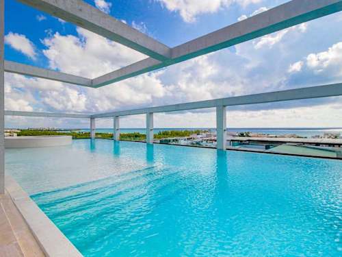 Shared rooftop infinity pool with loungers
