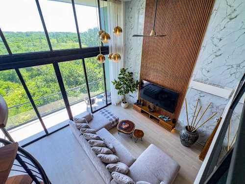 Cozy sitting nook beside floor-to-ceiling windows with green treetop views, a serene corner to slow down