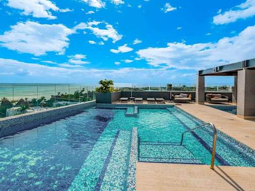 Shared rooftop infinity pool overlooking the Caribbean