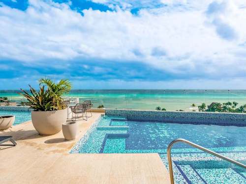Shared rooftop infinity pool with ocean views