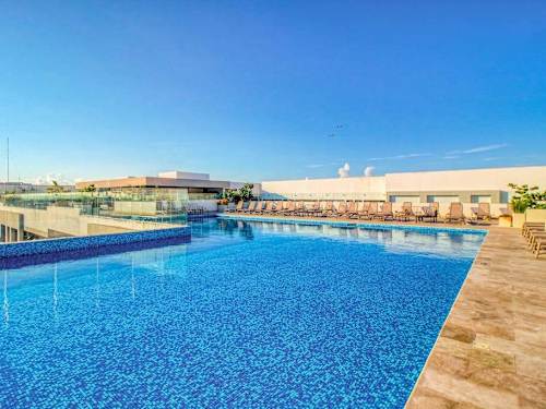 Shared rooftop pool with sun deck and ocean views
