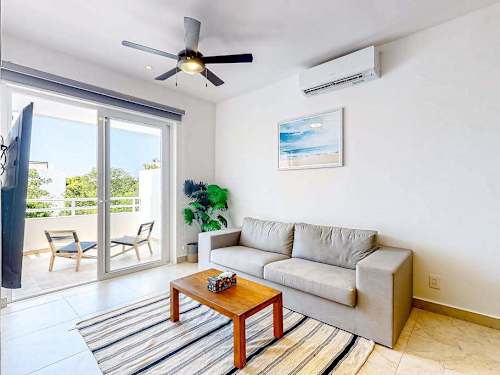 Bright living room with balcony access and ceiling fan
