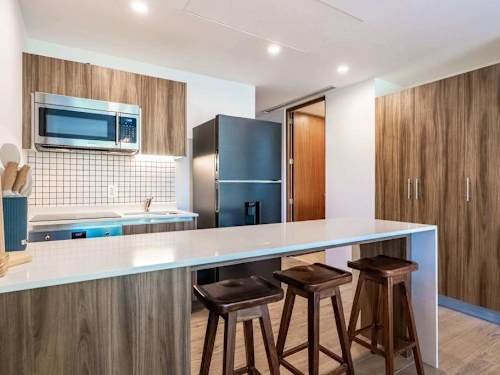 Fully equipped kitchen with warm wood cabinetry and a breakfast bar, everything you need to cook in