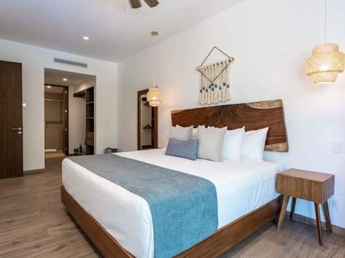 Restful king bedroom with soft linens and woven pendant lights, a calm retreat in Playacar