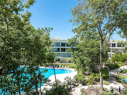 Living room with balcony and greenery views