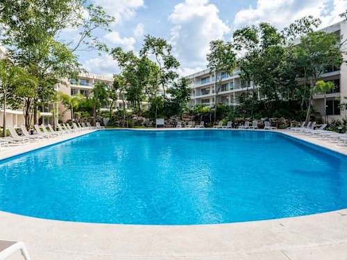 Sparkling resort pool wrapped in tropical greenery, your daily escape near Fifth Avenue and the beach