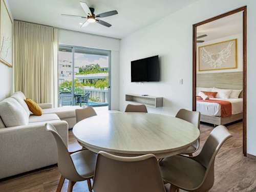 Bright living and dining space with a flat screen and round table, comfortable indoor living