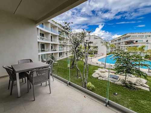 Private balcony with seating overlooking the pool and gardens, a quiet spot for morning coffee