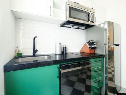 Compact green kitchenette with microwave and sink, easy prep for coffee and quick bites
