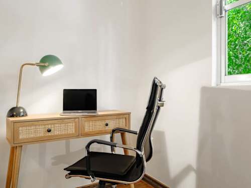 Bright workspace with a woven desk and an ergonomic chair, get work done steps from Parque Lincoln