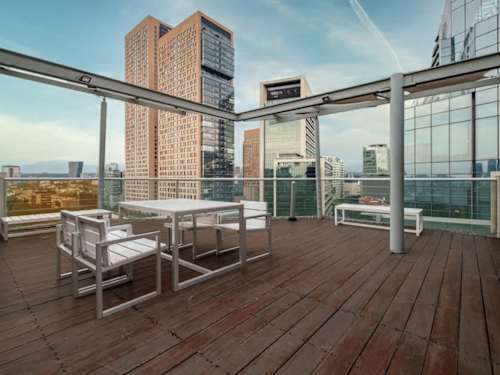 Rooftop terrace with lounge seating and towering skyline views, the perfect place to catch the sunset