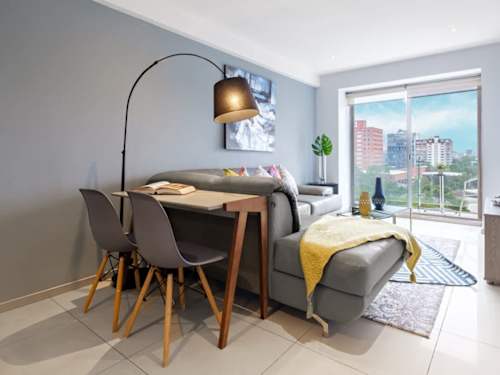 Sunny dining area with a stylish table framed by city-view windows, dine above the Polanco rooftops