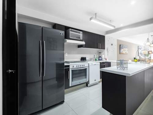 Sleek kitchen with a full-size fridge, gas range and island, everything you need to cook a proper meal