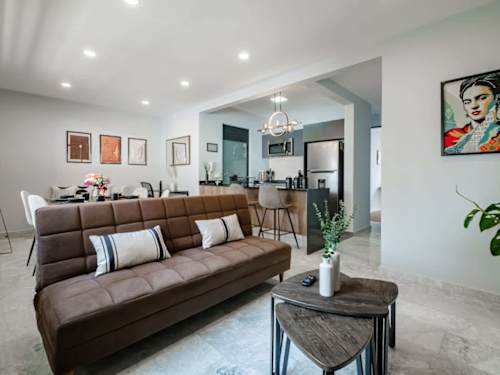 Bright, open living area with a rich leather sofa and layered art, easy indoor lounging in Roma Norte
