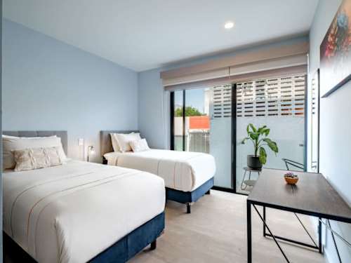 Airy bedroom with a comfy king bed and greenery-framed windows for a great night's sleep