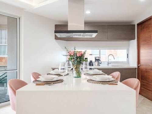 Elegant dining table set for guests with blush chairs, ready for a memorable meal