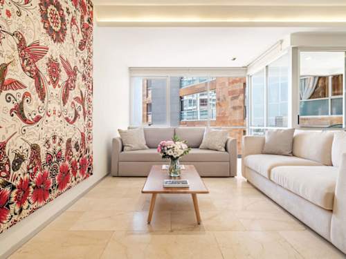 Statement living room with a bold floral tapestry and soft sofas, design and comfort together