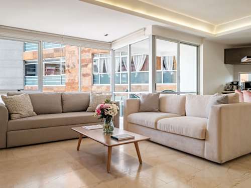 Bright, open living room with plush sofas and skyline windows, easy lounging with a view