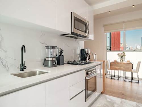 Full kitchen with a gas range, blender and city-view window, everything you need to cook in