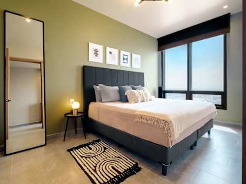 Serene king bedroom with a gallery wall and skyline windows, a restful retreat above the city