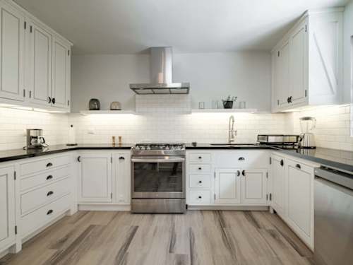 Bright white kitchen with a stainless range and ample cabinetry, everything you need to cook and gather