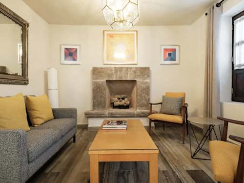 Cozy living room anchored by a stone fireplace and soft sofa, a warm space to unwind in the evenings