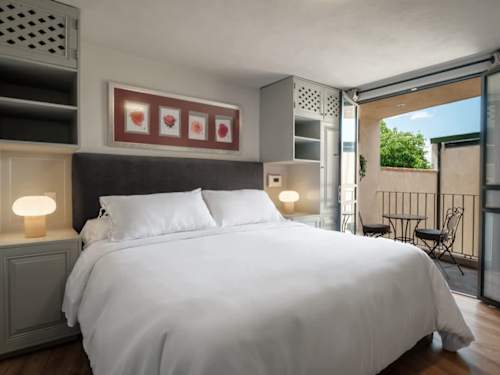 Restful bedroom with a plush bed and tasteful art, a calm retreat in the colonial city center