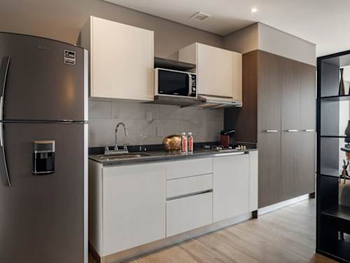 Sleek kitchenette with fridge, microwave and clean counters, easy to cook in near Monumento a la Revolucion