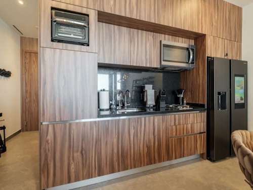 Sleek kitchenette with full-size fridge and coffee station, morning brew made simple